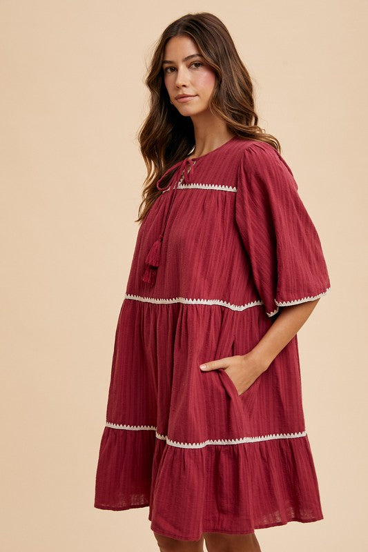 Aaliyah® | Tiered dress with tassels and contrast trim, tied neckline, half sleeves