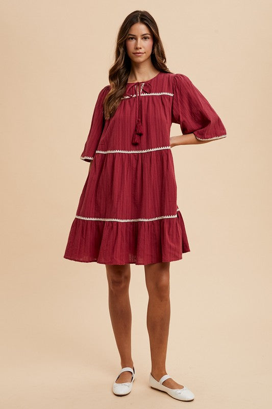 Aaliyah® | Tiered dress with tassels and contrast trim, tied neckline, half sleeves