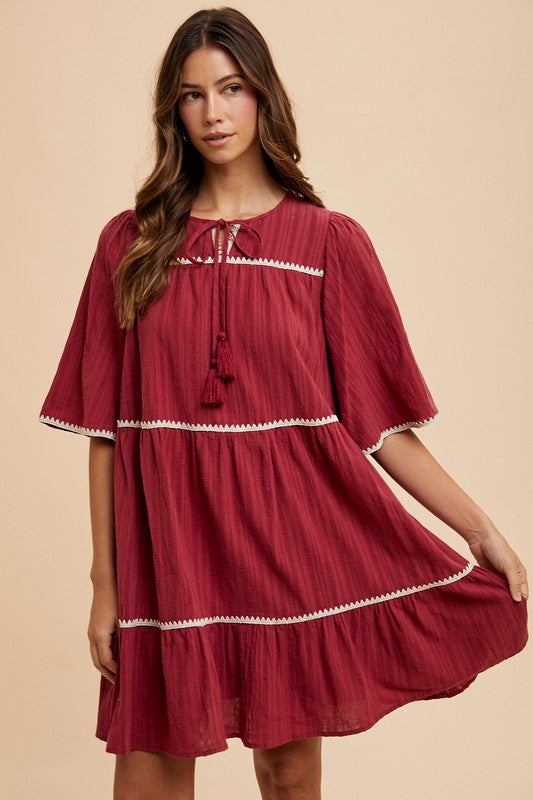 Aaliyah® | Tiered dress with tassels and contrast trim, tied neckline, half sleeves