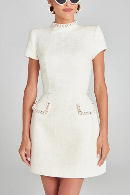 Leslie® | Exquisite and playful mini dress made of tweed fabric with beaded trim, short sleeves and pockets