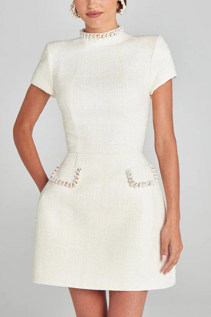 Leslie® | Exquisite and playful mini dress made of tweed fabric with beaded trim, short sleeves and pockets